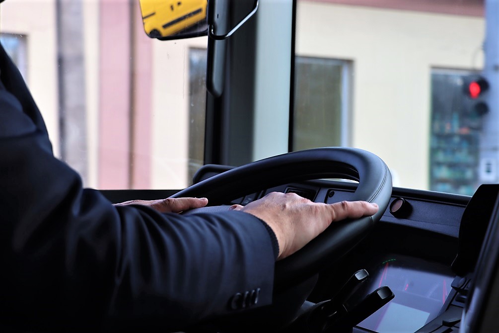 Volvo autóbusz volánját fogja egyenruhás autóbusz-vezetőnk