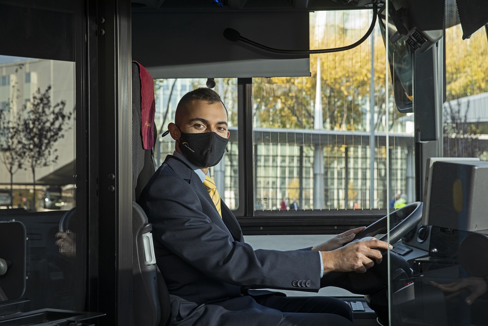 Autóbuszvezető maszkban járművön