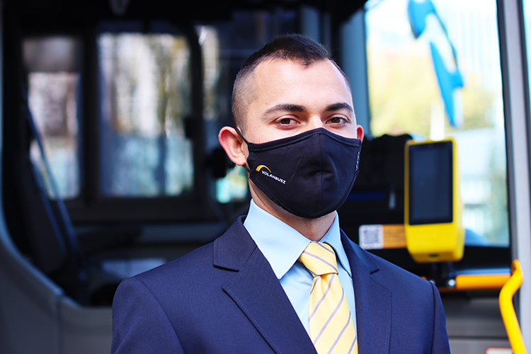 autóbuszvezető volánbuszos fekete maszkban az autóbusz előtt