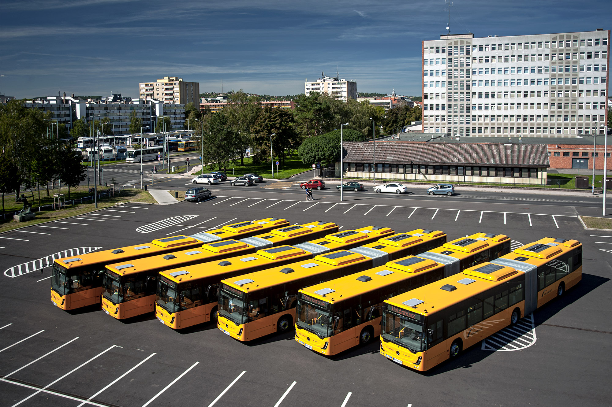 A képen a Mercedes-Benz Conecto G típusú csuklós autóbuszok láthatók madártávlatból.